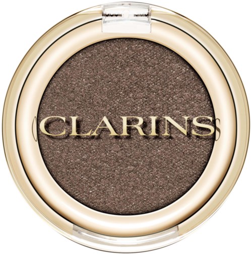 En rund ögonskugga med brunt utanpå och Clarins-loggan på.