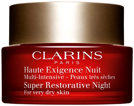 En röd burk med gyllene lock, märkt Clarins Paris Haute Exigence Nuit för mycket torr hy.