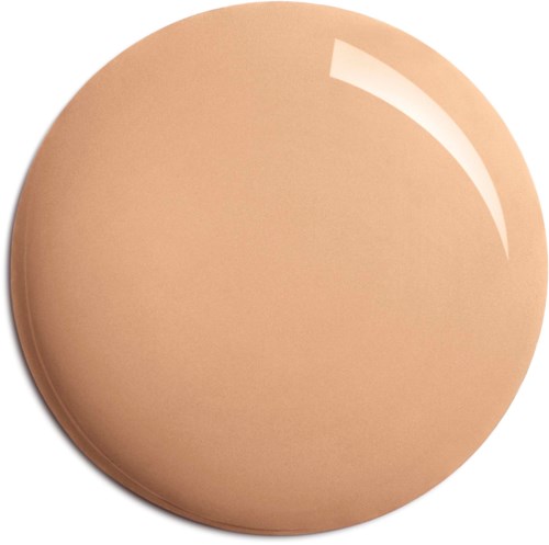 En rund, beige makeup-kompakt med en glansig yta och en lätt reflex.