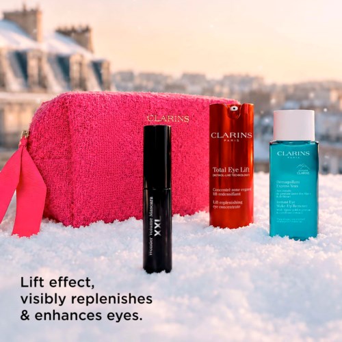 Produkty do pielęgnacji skóry Clarins na śniegu z różowym ręcznikiem, wspomagające poprawę i pełnię oczu.