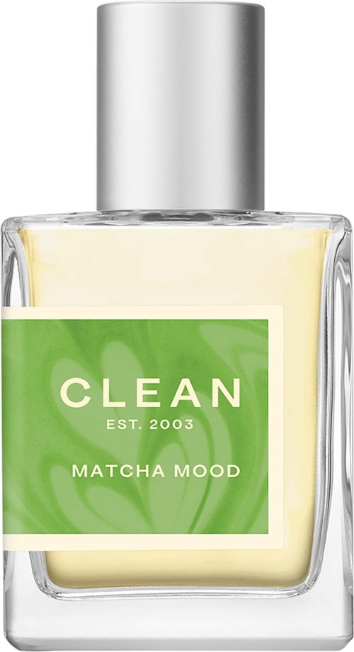 Een doorzichtige glazen fles met een zilveren dop, groene label met witte tekst, bevat een huidverzorgingsproduct genaamd Matcha Mood.