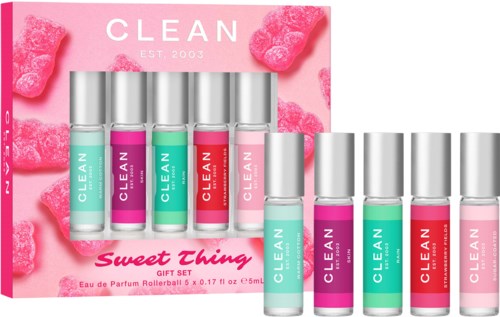Ett set med läppglans i rosa, grönt och rött, med rosa bakgrund och fluffiga rosa dekorationer.
