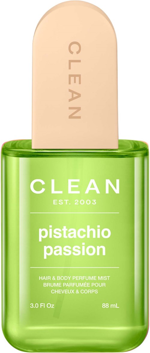 Eine grüne Sprühflasche mit beigem Deckel, beschriftet mit 'CLEAN' und 'pistachio passion' für Haar- und Körperspray.