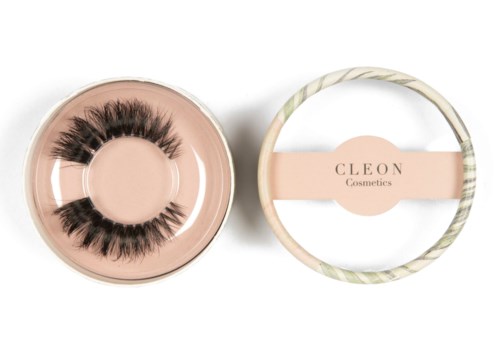 Falska fransar i en rund behållare, med en dekorerad box märkt 'CLEON Cosmetics' i närheten.