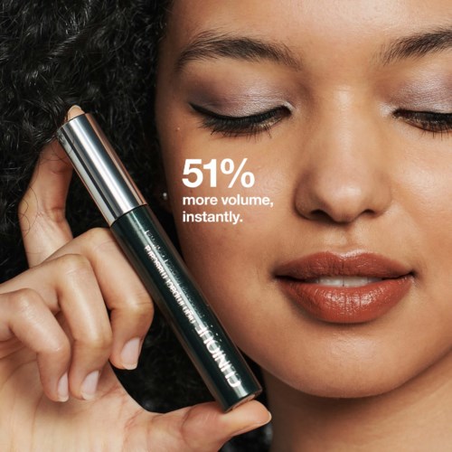 En kvinna håller ett mascaraförpackning med texten: '51% mer volym, direkt.' Hon har makeup och stängda ögon.