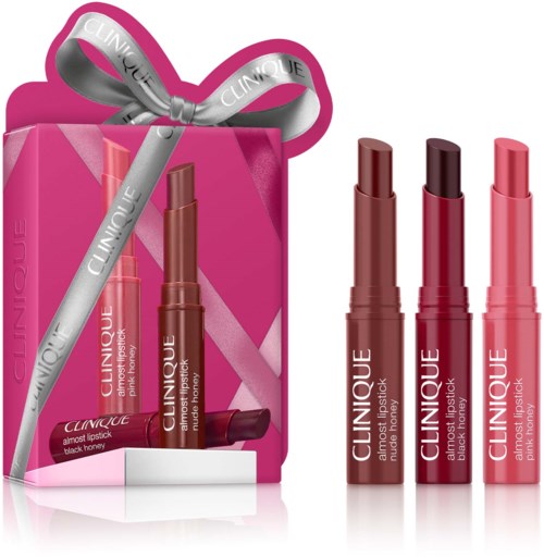 Tre Clinique læbestifter i nuancer afbrun og pink med en pink gaveæske og sølvbånd.