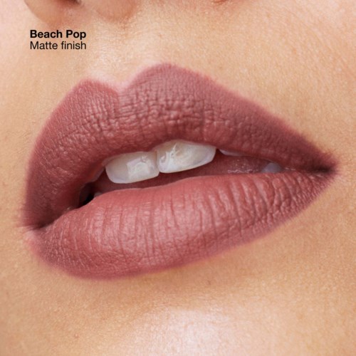 Nahaufnahme von Lippen mit mattem, rosa-beige Lippenstift, leicht geöffnet und zeigt Zähne.