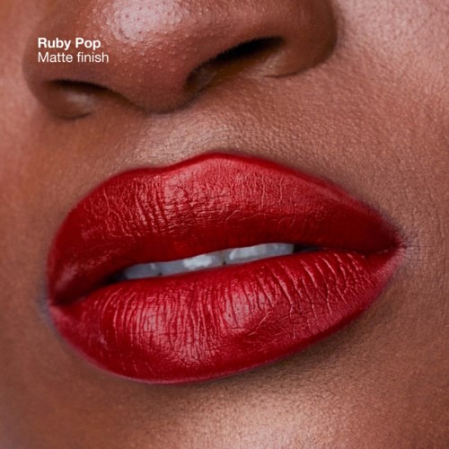 Close-up of lips with ruby red matte lipstick, showing the texture and shine of the lips.
