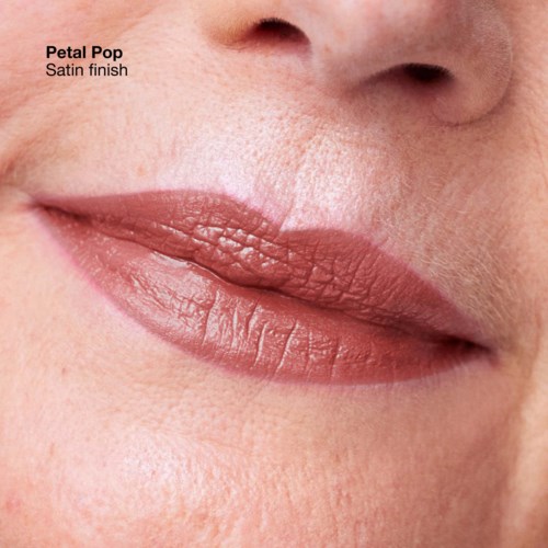 A close-up of lips with a matte, pinkish-brown lipstick called Petal Pop, satin finish. Skin and nose are also visible.