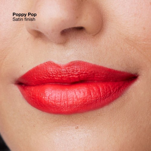 Lipstick with a satin finish in a bright red color on lips and part of nose and skin.