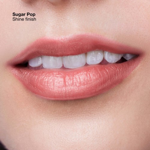Close-up of lips with teeth showing, soft pink lipstick, smooth skin, and text about the lipstick shade.