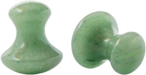 Två gröna jade schackpjäser, en står upp och en ligger på sidan.