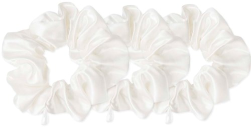 A white scrunchie made of soft fabric, arranged in a circle, with a black background.