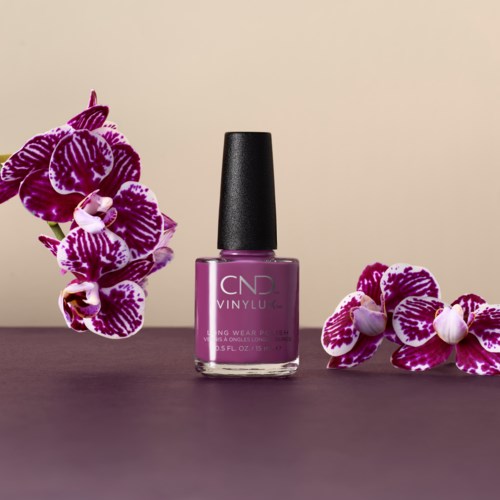 En flaska med lila nagellack med rosa och vita orkidéer på vardera sida.