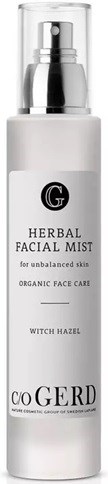 En hvit flaske med pumpe merket 'Herbal Facial Mist' for hud, inneholder witch hazel og økologisk ansiktspleie.