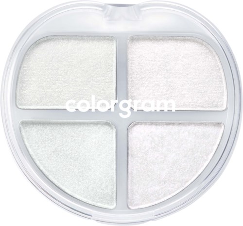 En rund makeup-palett med fyra vita puderavsnitt och tydligt lock, märkt "color gram."