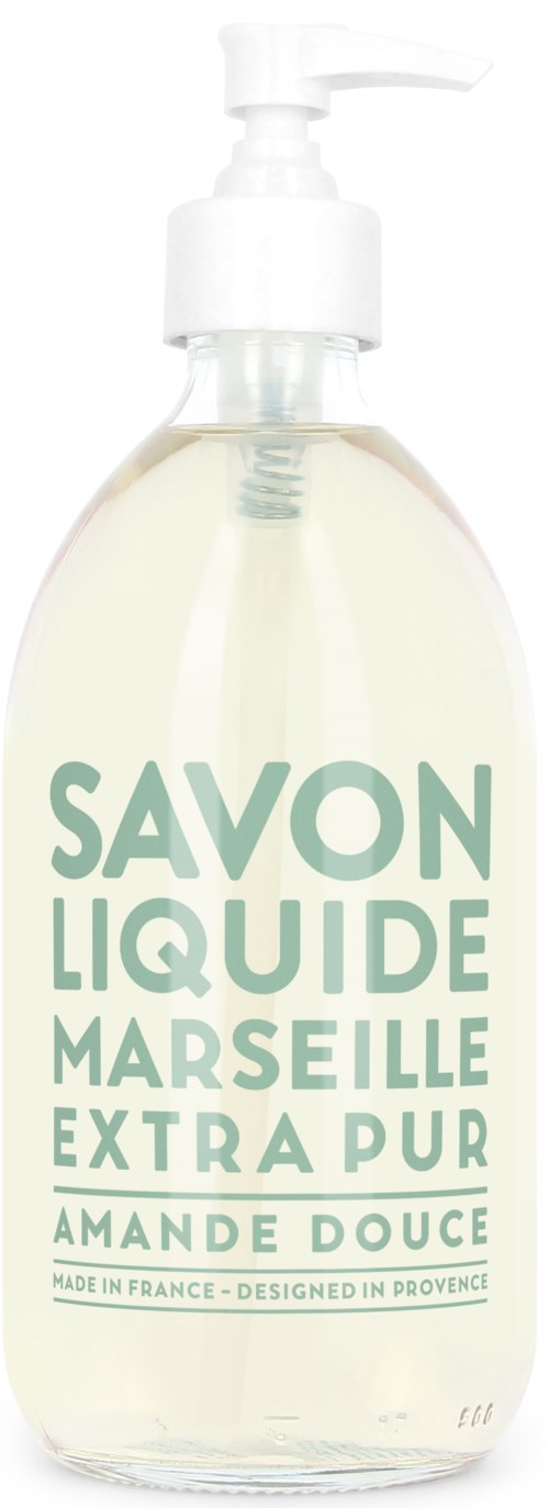 En klar flydende sæbe i en gennemsigtig pumpeflaske med grøn tekst, mærket "Savon Liquide Marseille Extra Pur Amande Douce."