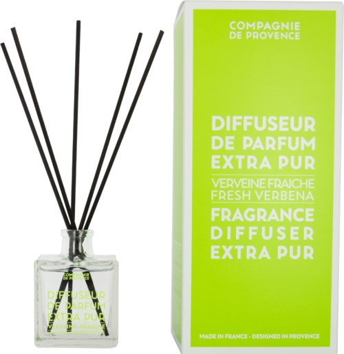 A perfume diffuser in a glass bottle with black sticks, and packaging in bright green with white text.