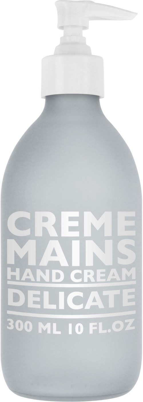 En grå håndkremflaske med pumpe, merket "CREME MAINS HAND CREAM DELICATE," 300 ml.