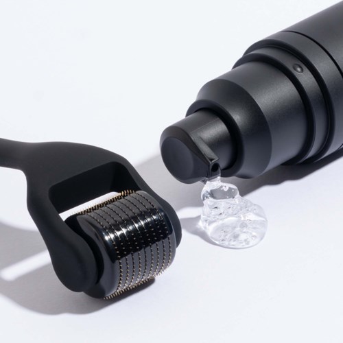 Ein schwarzer Gesichts-Roller und eine schwarze Flasche, die Gel oder Serum abgibt, auf weißem Hintergrund.