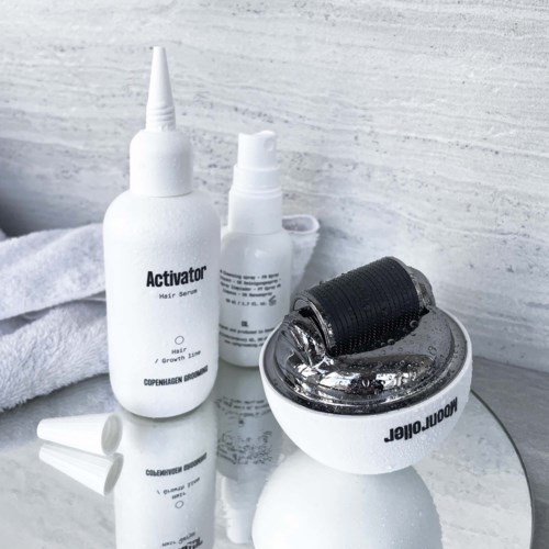 Ett hudvårdsset med flaskor och en rulle, inklusive ett serum, spray och en enhet för hudvård.