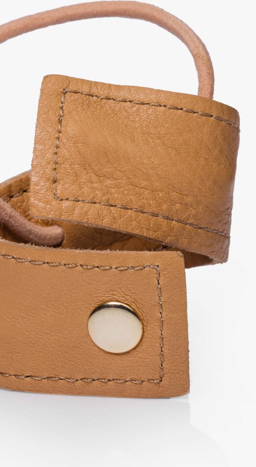 A brown leather strap with a metal button and a loop, likely a belt or watch strap.