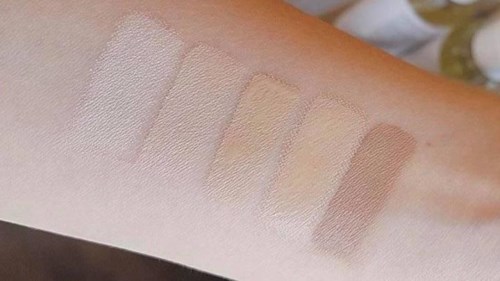 Fyra olika nyanser av ljusfärgade makeupprov på armen. Ljus till mörkare beige toner. Ögonskuggor eller ansiktsmakeupprover.