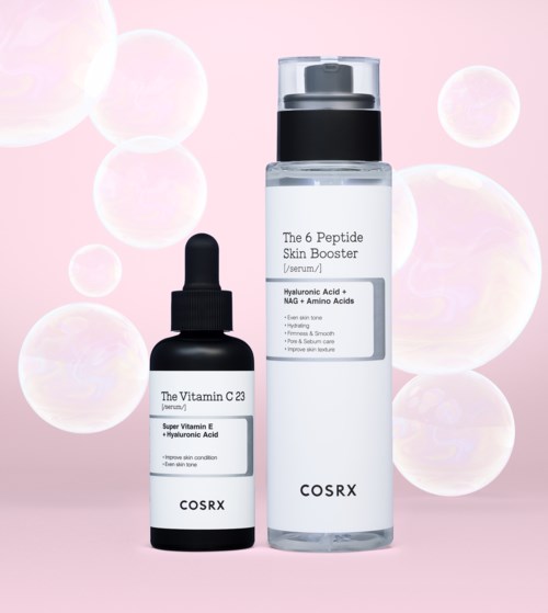 Two skincare bottles, one small with a dropper, and one larger, on a pink background with bubbles.