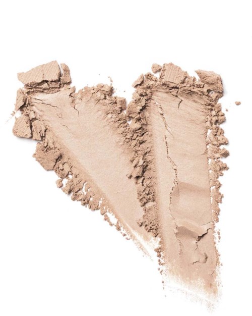 A heart shape is made from light beige powder, possibly makeup or chalk, with rough edges on a white background.