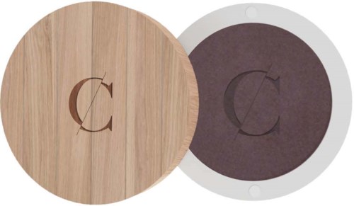 Two round objects with a 'C' logo, one wood-colored and the other dark, in a container. It looks like coasters.