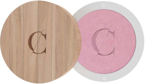 A wooden coaster with a circular cutout showing pink paper behind, both have a letter C cutout.