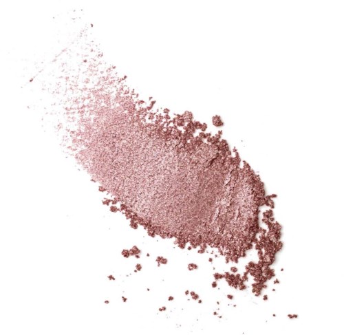 A scattered, reddish powder or glitter on a white background, forming an uneven shape with some loose particles.