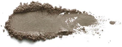 Gray powder spread out, with some scattered particles around it.