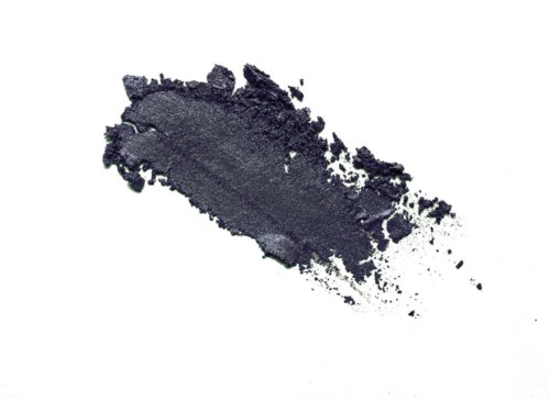 A dark gray smudge or streak on a white background, resembling makeup or paint.