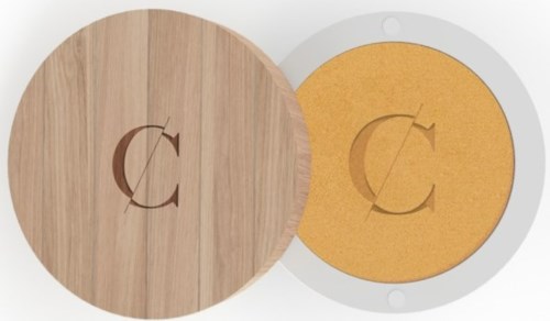A round wooden lid and a round yellow sponge inside a white container with a logo. The logo is a curved line and a letter C.