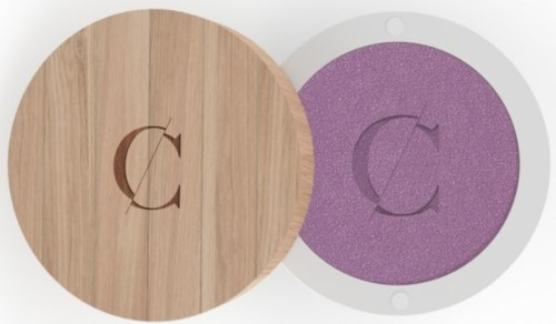 A wooden and purple sponge with a circular shape, each featuring the letter C engraved or printed on top.