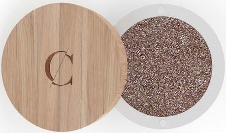A wooden and glittery round item with a letter 'C' on the wood. It looks like a compact or a case.