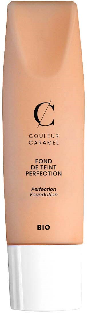 Długa butelka podkładu w kolorze brzoskwiniowym z białą zakrętką i czarnym tekstem, oznaczona 'PERFECTION FOUNDATION BIO'.