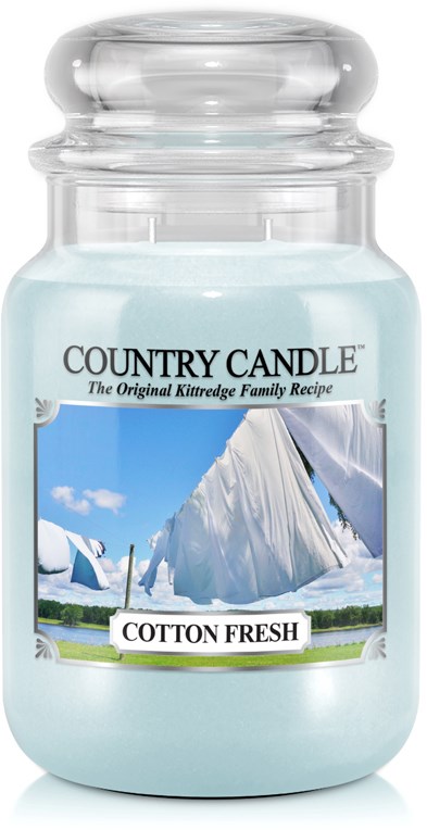 Een pot met lichtblauwe geurkaars labeled 'Cotton Fresh' met een buitenscène op het label.