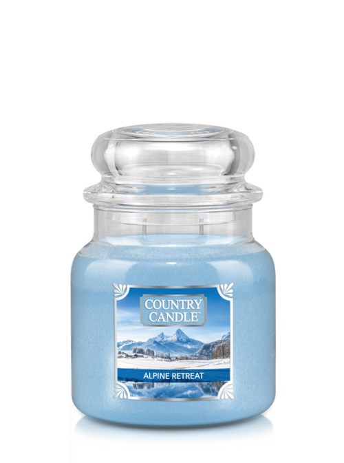 Ett blått ljus i en glasburk märkt "Alpine Retreat" från Country Candle.