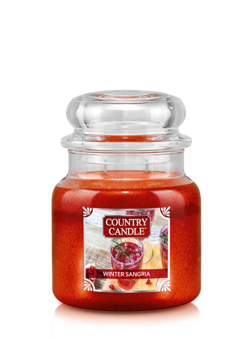 Ett rött doftljus i en glasburk med etikett som säger "Country Candle" och "Winter Sangria."