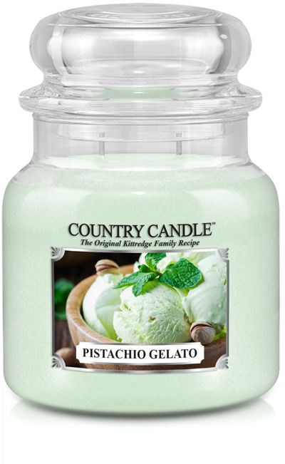 Et hvidt duftlys i glas med etikette 'Pistachio Gelato' og et billede af grøn is med mynte.