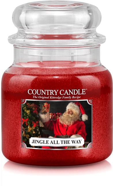 Ett rött ljus i ett glasskärl med en julrelaterad etikett som visar tomten och juldekorationer.