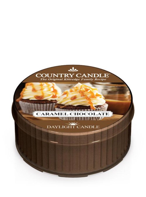 Ett chokladljus med karamell och vispgrädde på toppen i en rund brun behållare.