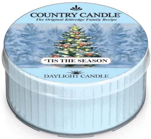 En rund ljusbehållare med en julgran och snöbakgrund, märkt 'Country Candle' och 'Daylight Candle.'