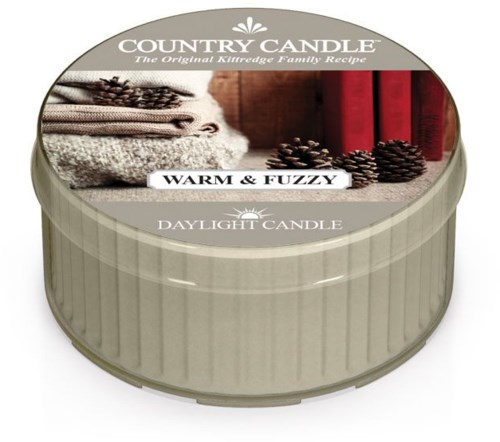 En rund ljusburk med etikett: "Country Candle," som visar handdukar, kottar och böcker, märkt "Warm & Fuzzy," för dagtid.