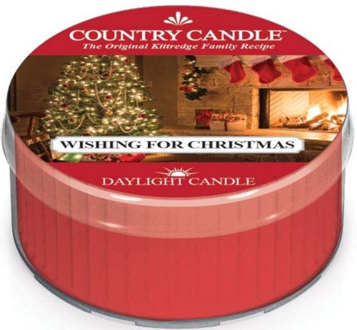 A round candle container with a Christmas scene, including a decorated tree and a fireplace with stockings.