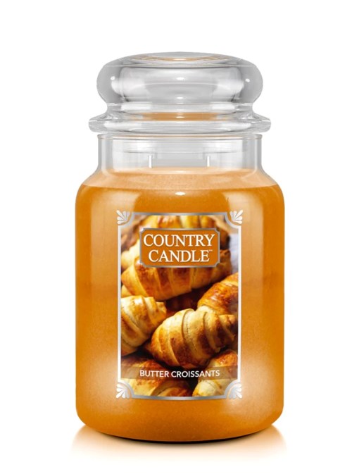 Eine Kerze in einem Glas mit dem Label 'Country Candle' und einem Bild von Croissants, Duft ist Butter Croissants.
