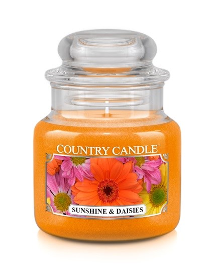 En liten orange ljuslykta med en etikett med färgglada blommor, märkt "Country Candle" och "Sunshine & Daisies."
