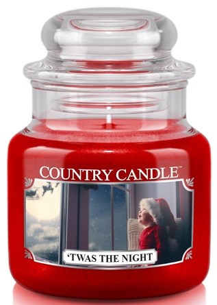 Et rødt lys i glass har et bilde av et barn i nissehatt og teksten 'Twas the Night' og 'Country Candle'-logoen.